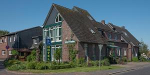 a large brick building with a black roof at Hotel am Elisabethufer in Jever