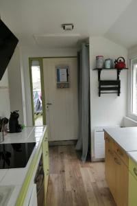 een keuken met een deur naar een kamer bij Les Camélias in Loctudy