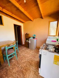 a kitchen with a stove and a table at Cabañas Turi Lackar in San Pedro de Atacama