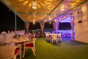 a dining room with tables and chairs and lights at Krishna Stay Guest House in Udaipur