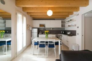 una cucina e una sala da pranzo con tavolo e sedie bianchi di Ca' Martina a Venezia
