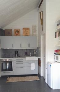 kuchnia z białymi szafkami i kuchenką w obiekcie The Studio w mieście Klövedal