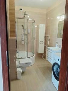 a bathroom with a shower and a toilet and a sink at Parkcity Kraków pro in Krakow