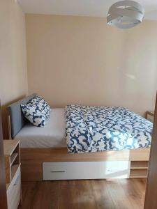 a bedroom with a bed with blue and white sheets at Parkcity Kraków pro in Krakow