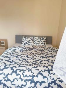 a bedroom with a bed with a blue and white comforter at Parkcity Kraków pro in Krakow