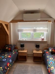 una piccola camera con due letti e una finestra di Dom ul. Otrocz Nowy 1 