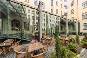 a patio with tables and chairs and a building at TRIBE Riga City Centre in Rīga
