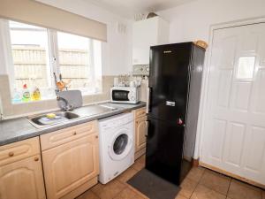 a kitchen with a black refrigerator and a dishwasher at The Hawthorns in Chester