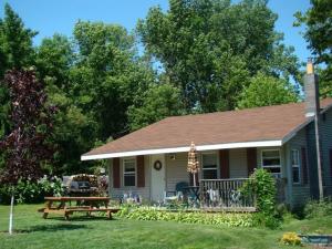 a house with a picnic table in the yard at Lynns Cottage at Heron Ledge in Plattsburgh