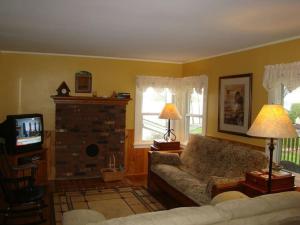 a living room with a couch and a tv at Lynns Cottage at Heron Ledge in Plattsburgh