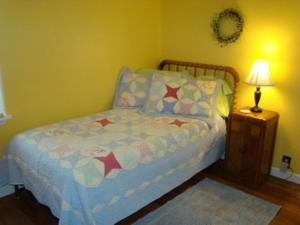 a small bed in a room with a lamp at Lynns Cottage at Heron Ledge in Plattsburgh