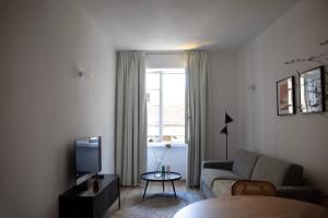 Bob W Ponte Vecchio في فلورنسا: غرفة معيشة مع أريكة وتلفزيون