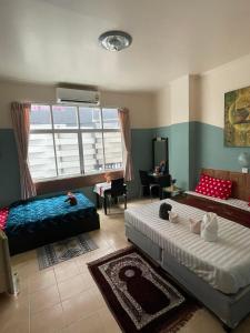 a living room with two beds and a couch at San Antonio Beach Guesthouse & Restaurant in Kata Beach