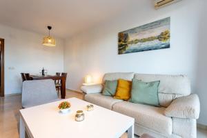 a living room with a couch and a table at MalagaSuite Dreamy Village in Arroyo de la Miel