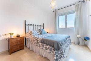 a bedroom with a bed and a dresser and a window at MalagaSuite Dreamy Village in Arroyo de la Miel