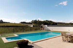 a swimming pool in the yard of a house at Casa dos Mirtilos Draper T6 in Celorico de Basto