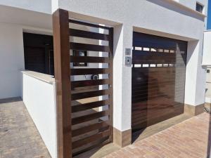 een houten poort in een huis met een garage bij La Casa Costera Càlida in San Pedro del Pinatar