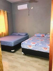 2 łóżka pojedyncze w pokoju z wentylatorem w obiekcie Casa Birnbaum Ruiz Diaz w mieście Carapeguá