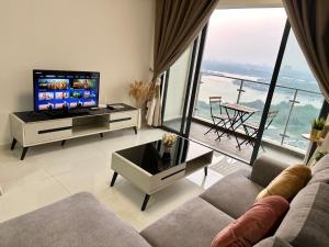 a living room with a couch and a tv and a balcony at Golden Tree @ Country Garden Danga Bay in Johor Bahru