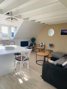 een woonkamer met een witte tafel en stoelen bij T2 - T3 Vue exceptionnelle - Centre ville de Dinard in Dinard