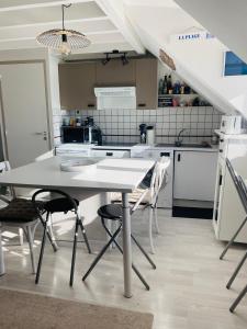 een keuken met een witte tafel en stoelen bij T2 - T3 Vue exceptionnelle - Centre ville de Dinard in Dinard