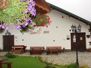 a building with benches and flowers on the side of it at Pensiunea Rhein in Azuga