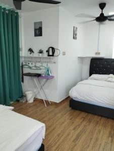 1 dormitorio con 2 camas y cortina verde en Inap Idaman 7 5 Pax 2 Queen Plus 1 Sofa Bed, en Kota Bharu 8 fotos más