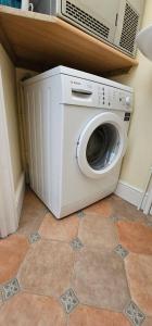 a washing machine sitting on the floor in a room at Beautiful Spacious 5 Bed House in Fornham Saint Martin