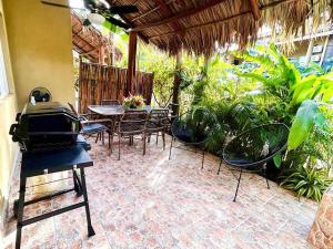 an outdoor patio with tables and chairs and a grill at Cabo Velas 19 Jungle Paradise in Santa Cruz