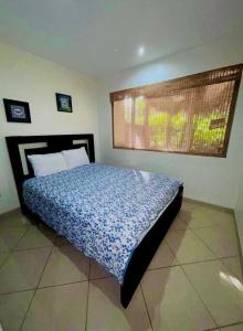 a bedroom with a bed with a blue comforter at Cabo Velas 19 Jungle Paradise in Santa Cruz