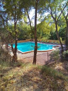 a swimming pool in a yard with trees at GÎTE DE L 'OCRE NICE VIEW in Villars