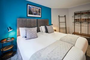 a bedroom with a large white bed with blue walls at Host & Stay - Narrowgate Apartments in Alnwick