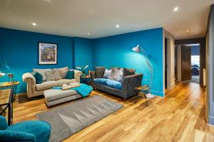 a living room with blue walls and a couch and chairs at Host & Stay - Narrowgate Apartments in Alnwick