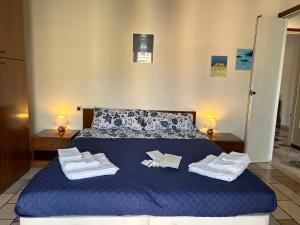 Un dormitorio con una cama azul con toallas. en Casa Valentina en San Donato Milanese