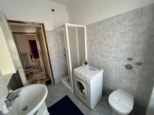 een badkamer met een wastafel en een wasmachine bij Casa Valentina in San Donato Milanese