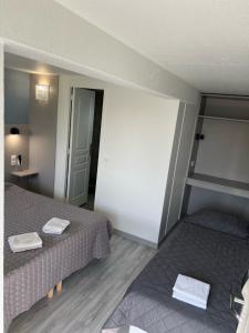 サン・ヴィッツにあるFasthotel Roissy - Saint-Witzのベッド2台、タオル付