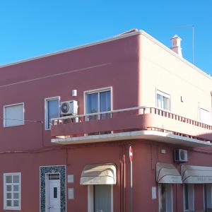 サン・バルトロメウ・デ・メシネスにあるCasa Algarvianaの赤い建物(バルコニー付)