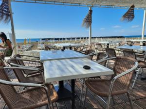 einen weißen Tisch und Stühle auf einer Terrasse mit Strand in der Unterkunft Sopraland T3 45m2 à 300m plage Richelieu in Cap d'Agde