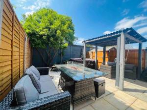 a patio with a table and a gazebo at Fullers mead in Potter Street