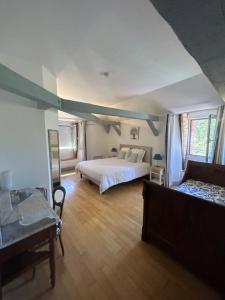 ein großes Schlafzimmer mit einem Bett und einem Sofa in der Unterkunft Maison Redon chambres d'hôtes in Tour-de-Faure