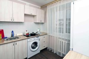 een keuken met een wasmachine en een wastafel bij Амстердам in Petropavlovsk