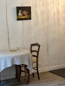 une table et une chaise avec une table et une photo dans l'établissement La Clé d'Anne, à Saint-Germain-en-Laye