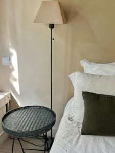 - une chambre avec un lit, une table et une lampe dans l'établissement La Clé d'Anne, à Saint-Germain-en-Laye