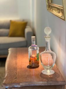 eine Glasflasche und eine Vase auf dem Tisch in der Unterkunft La Clé d'Anne in Saint-Germain-en-Laye