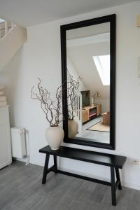 uno specchio nero seduto su un tavolo con un vaso di Luxuriöses Messe Apartment an der Leineinsel in Hannover, direkt am Wasser in ruhiger Laage ad Hannover