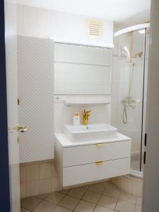 uma casa de banho branca com um lavatório e um chuveiro em Luxuriöses Messe Apartment an der Leineinsel in Hannover, direkt am Wasser in ruhiger Laage em Hanôver