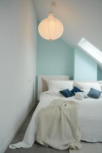 a bedroom with a white bed with blue walls at Luxuriöses Messe Apartment an der Leineinsel in Hannover, direkt am Wasser in ruhiger Laage in Hannover