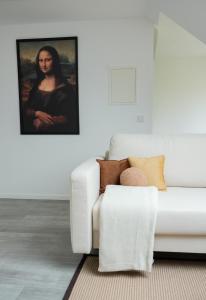 um sofá branco numa sala de estar com um quadro em Luxuriöses Messe Apartment an der Leineinsel in Hannover, direkt am Wasser in ruhiger Laage em Hanôver
