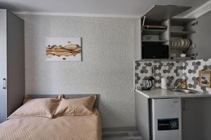 a small kitchen with a bed and a counter at Апарт 33 in Almaty