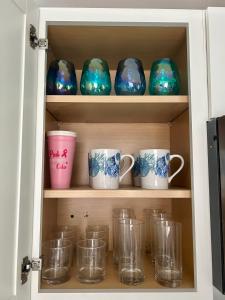 a cabinet filled with glass mugs and cups at Cocoa, Beach house in Cocoa